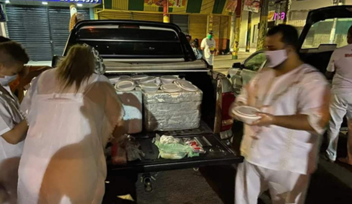 Voluntários do Projeto DoAxé entregando marmitas